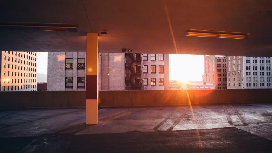 Car parked in urban downtown area surrounded by concrete buildings and structures