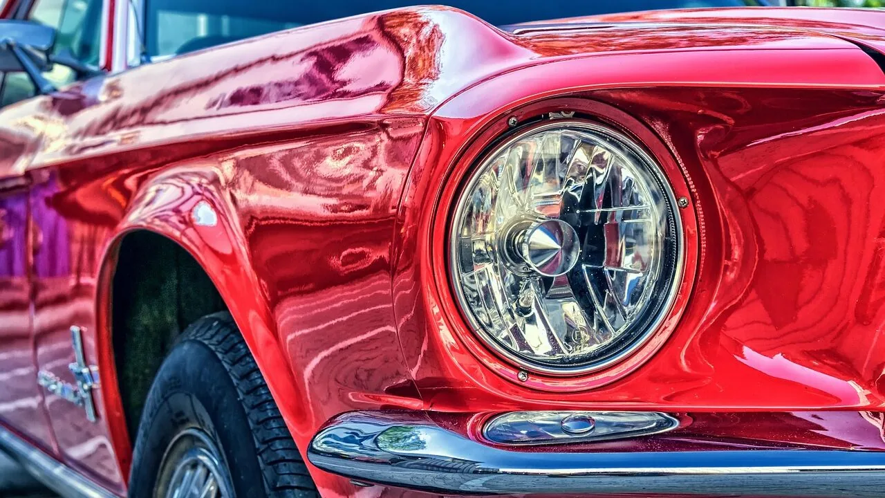 Car polish bottle displayed on shiny car hood with natural light reflection