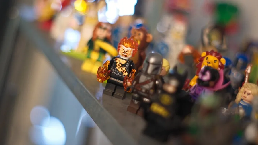 Carefully arranged collectible figures on wooden shelving unit with varied heights and spacing