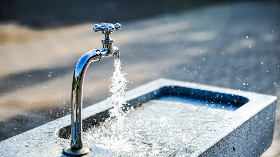 Cat drinking from a water fountain with flowing stream in home setting