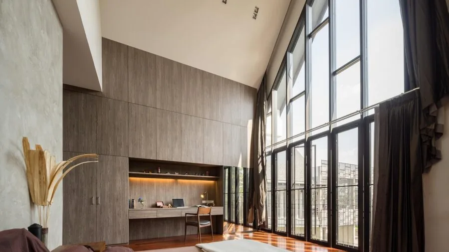 Cat exploring a bright, modern living room with furniture and natural light from windows