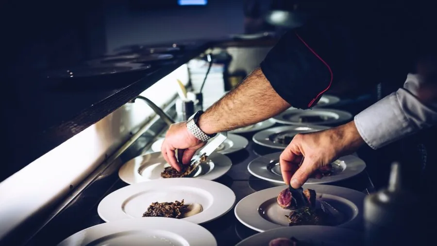 Chef in professional kitchen preparing fresh ingredients with careful hand technique