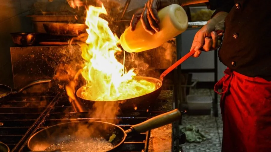 Chef inspecting saucepan construction and material quality in kitchen
