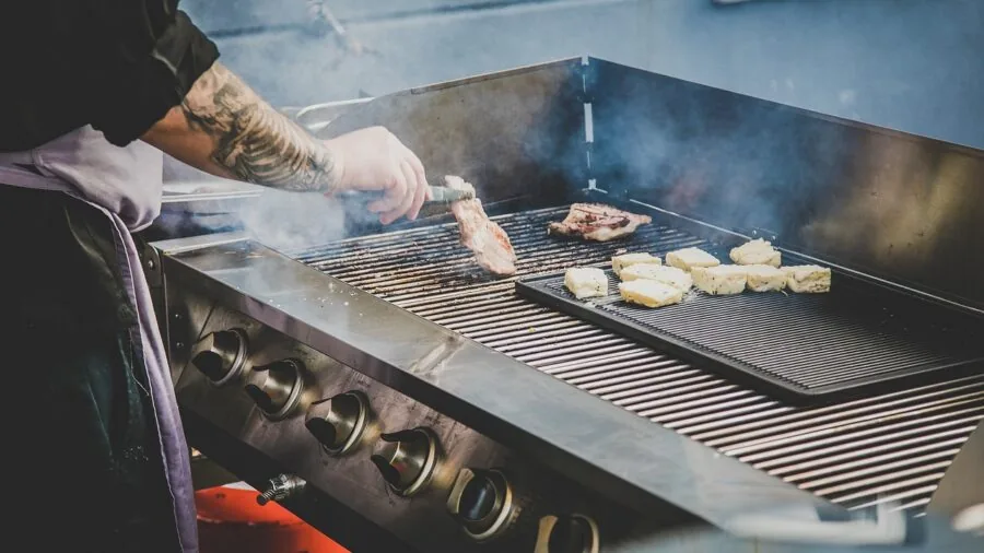 Chef using thermometer to verify meat doneness while cooking in kitchen