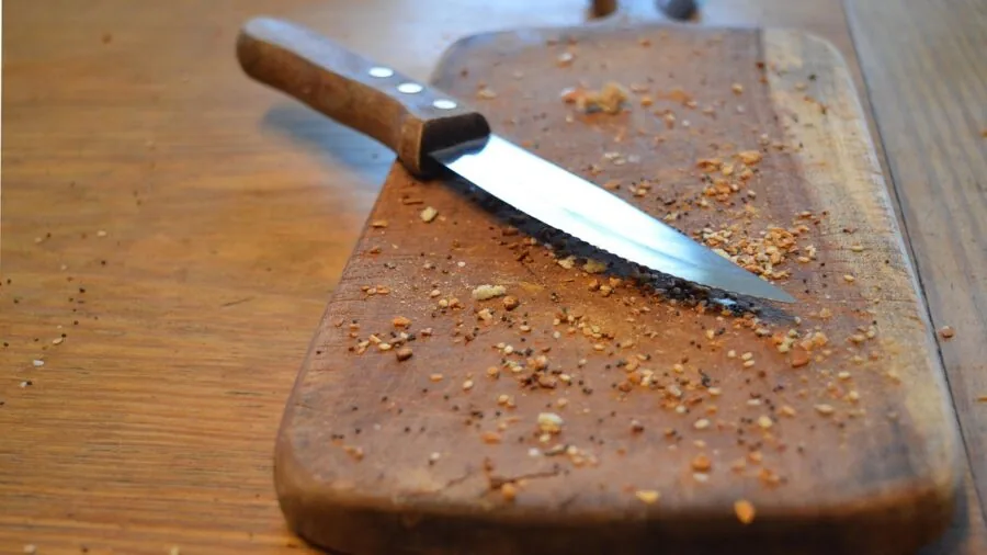 Chef working at kitchen counter with cutting board and fresh ingredients during food preparation