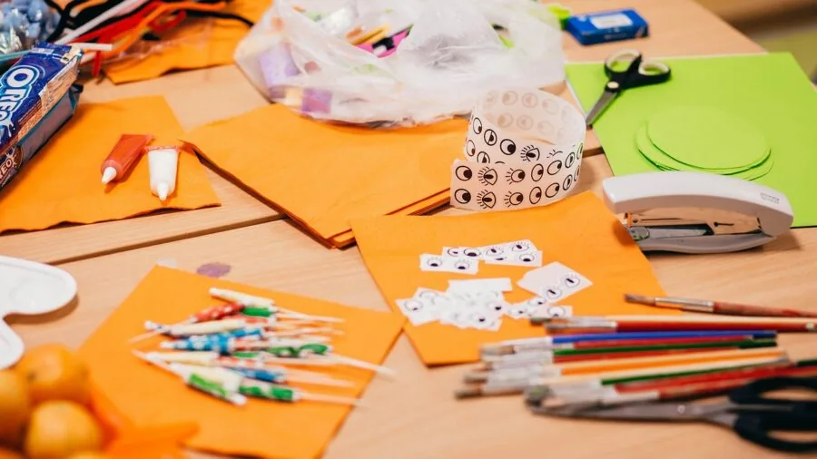 Child engaged in painting activity with colorful art supplies and creative workspace