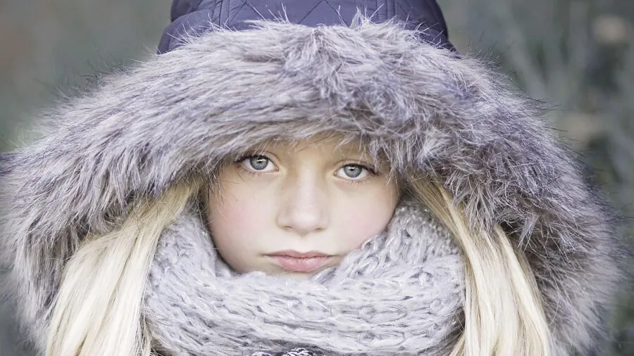Child in cozy winter coat playing outside in cold weather, demonstrating warmth and insulation