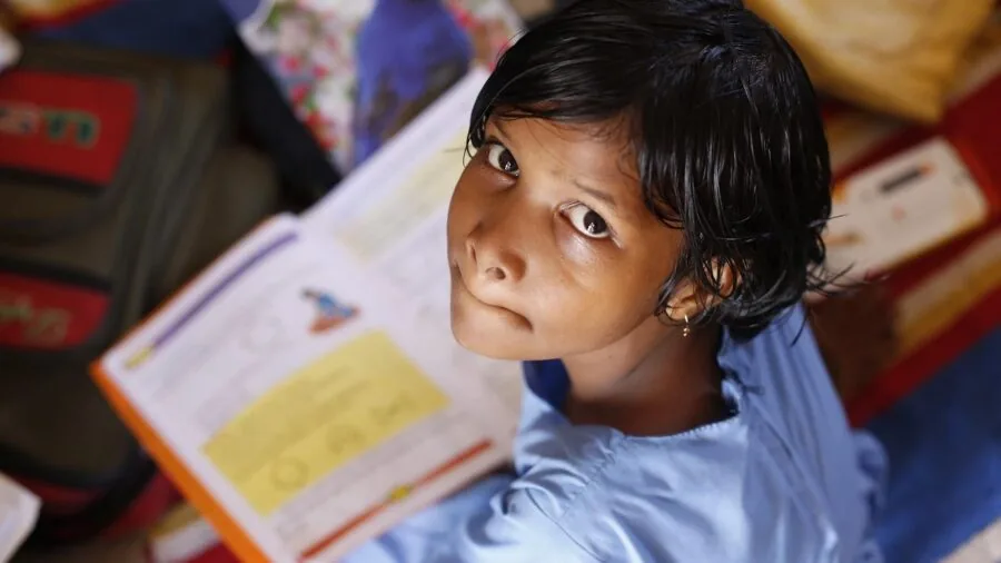 Child reading instruction manual while working on learning project independently at home
