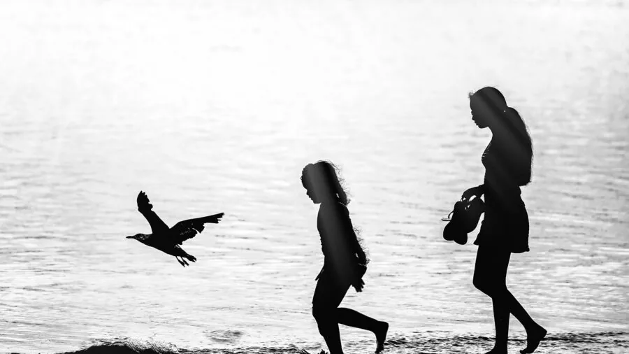 Child splashing and playing in water outdoors, demonstrating durability needs for kids' wearable devices