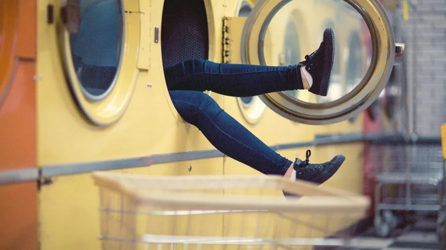 Child's colorful clothes being washed in a washing machine, representing frequent laundering of kids' garments
