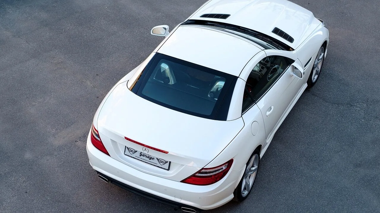 Clay bar tool removing contaminants from car paint surface during automotive detailing