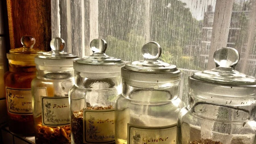 Clean baby bottles air drying on kitchen counter near sink with natural light