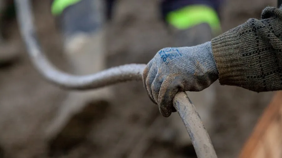 Close-up of a craftsperson's hands firmly gripping a worn leather tool handle during work