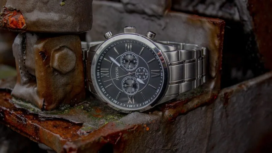 Close-up of a durable metal watch worn on wrist during outdoor adventure activity