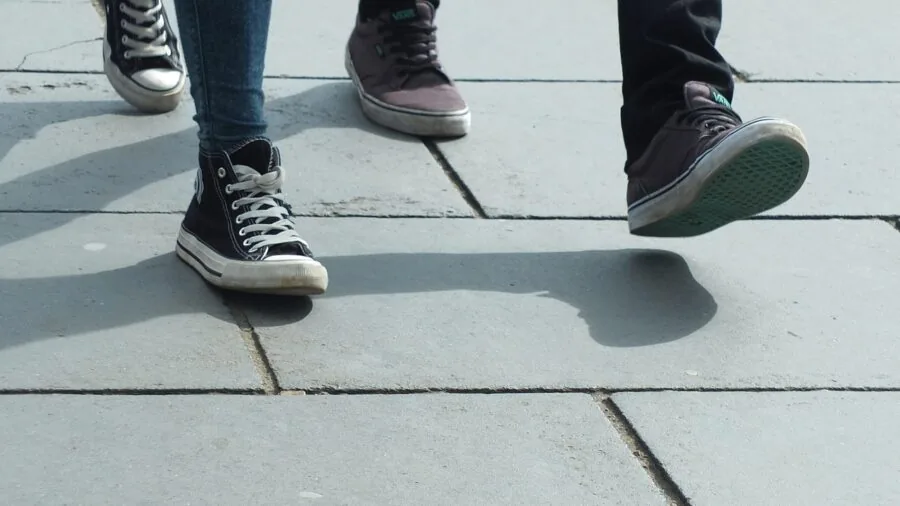 Close-up of a runner's feet in motion on a paved road during an outdoor run