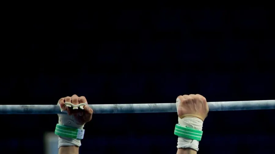 Close-up of athlete's hands gripping barbell during weightlifting session at gym