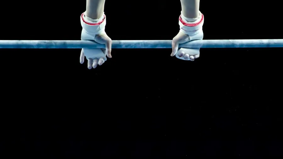 Close-up of athlete's hands gripping horizontal bar during strength training workout