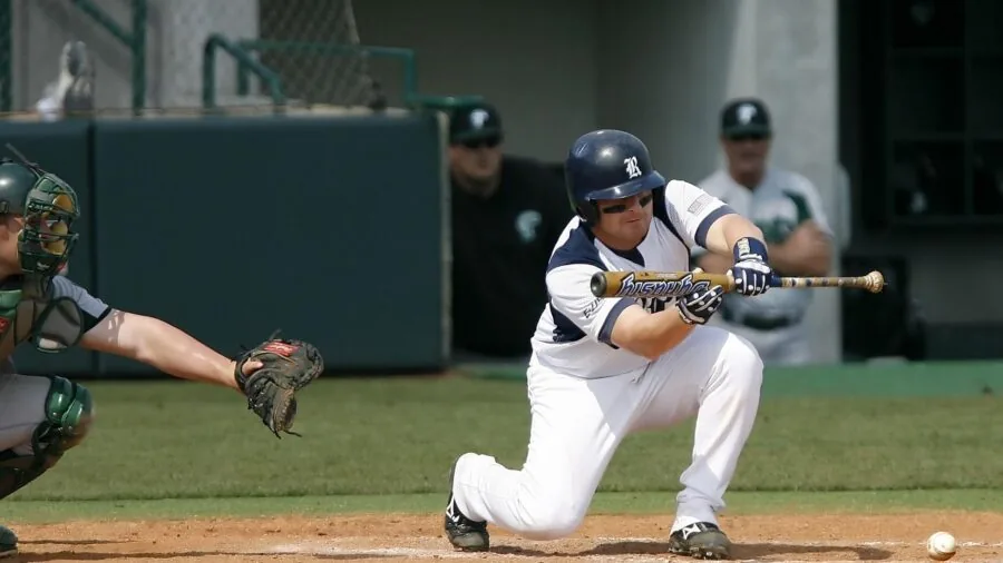 Close-up of baseball player's hands gripping bat during swing, showing grip technique and hand positioning