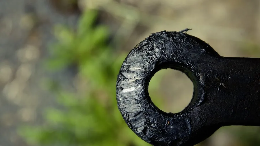 Close-up of bike trailer coupler connection being attached to rear bicycle axle outdoors