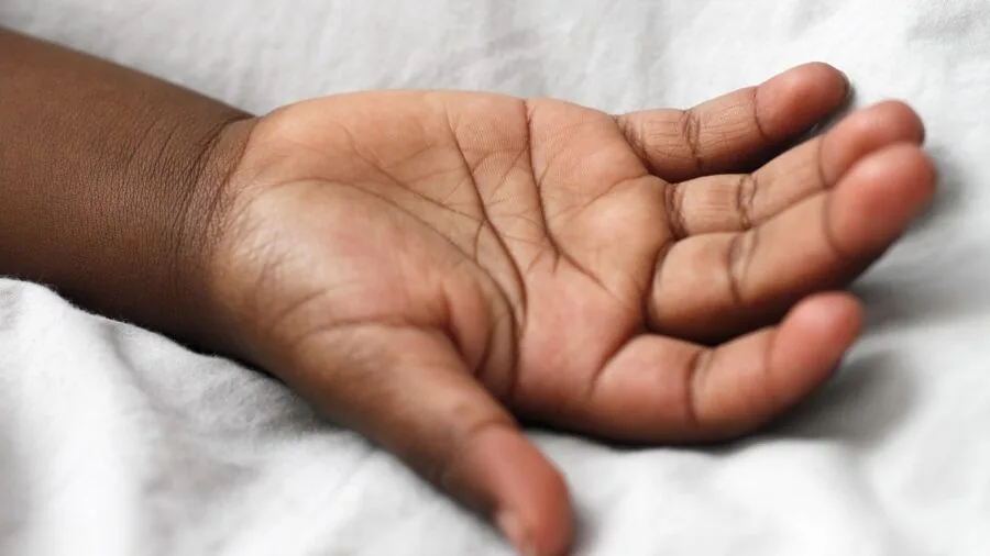Close-up of child's hands firmly gripping protective sports equipment with focus on safety grip