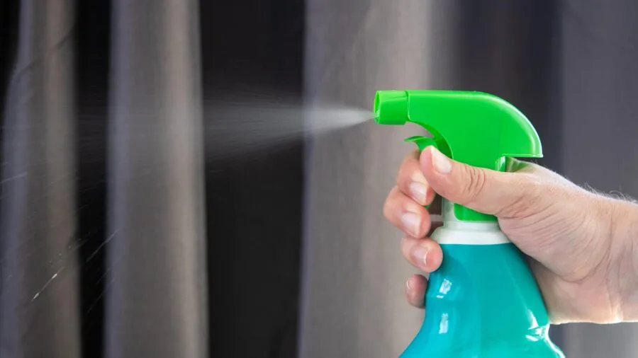 Close-up of cleaning solution being applied to car paint surface during detailing process