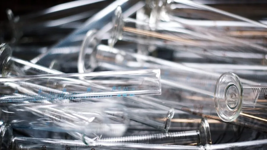 Close-up of clear glass measuring cylinder with liquid during laboratory measurement process