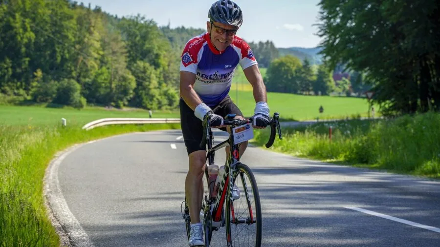 Close-up of cyclist adjusting sunglasses while wearing a bicycle helmet outdoors