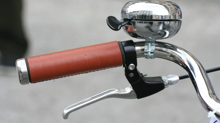 Close-up of cyclist's hands gripping bike handlebars during off-road cycling on rough terrain