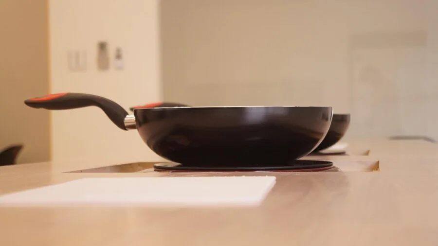 Close-up of different cookware materials and textures arranged on a kitchen counter during food preparation