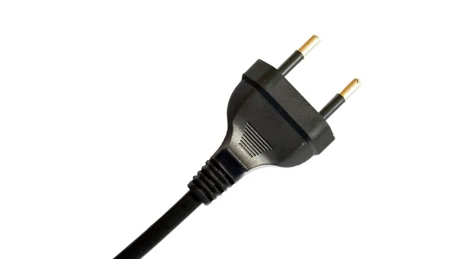 Close-up of electrical outlet with plugged-in appliance cord in residential setting