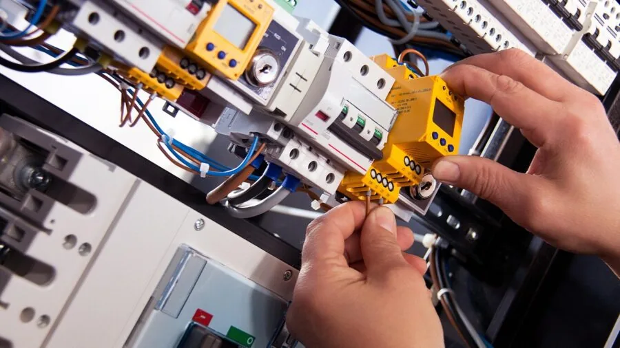 Close-up of electrician inspecting heavy-gauge electrical wire during installation work
