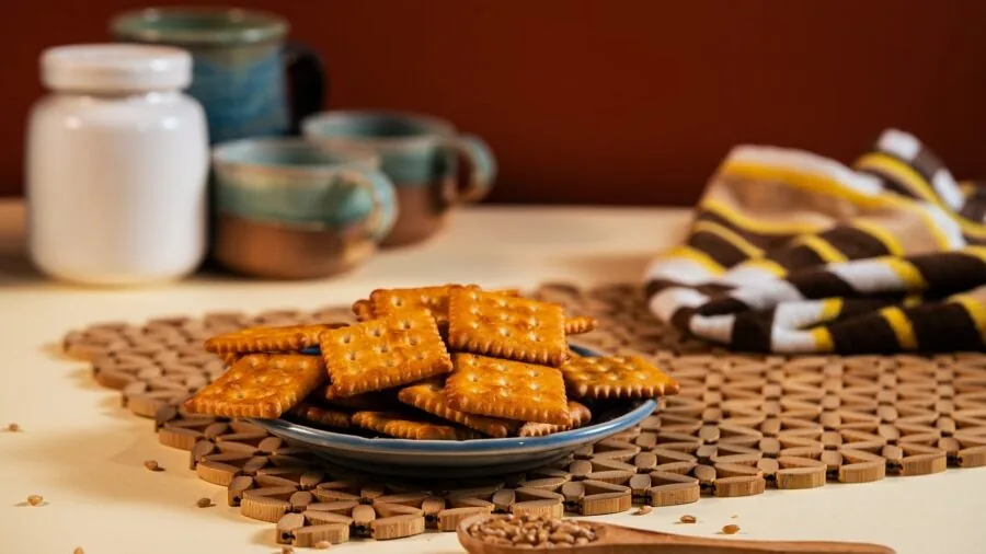 Close-up of elegant ceramic dinner plates stacked on a wooden table with natural lighting