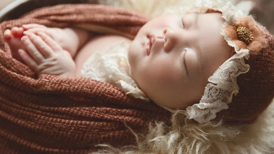 Close-up of gentle fabric texture touching delicate newborn skin, emphasizing softness and material quality