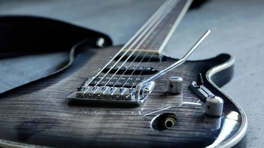 Close-up of guitarist's hands inspecting the curved fretboard of an acoustic guitar