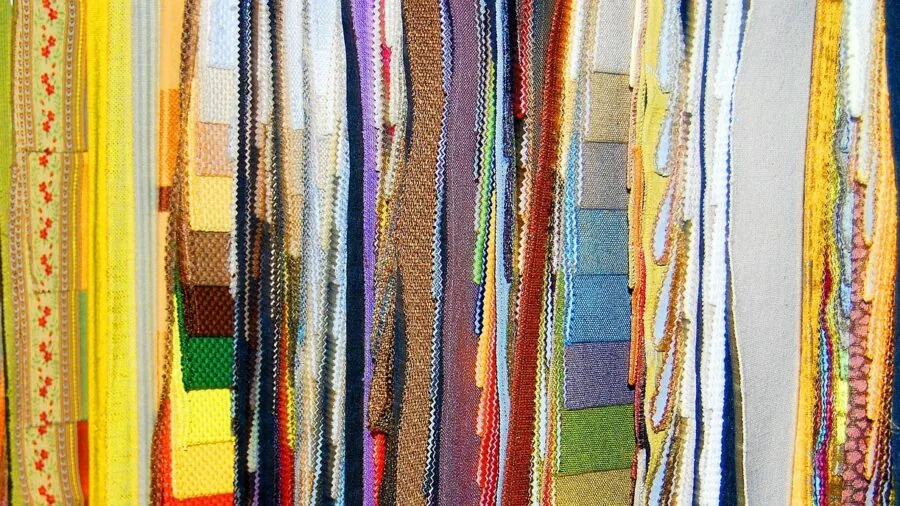 Close-up of hand touching different fabric textures and upholstery materials