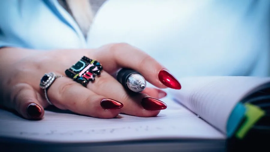 Close-up of hand writing in notebook with pen, capturing the natural feel of pen-on-paper writing experience
