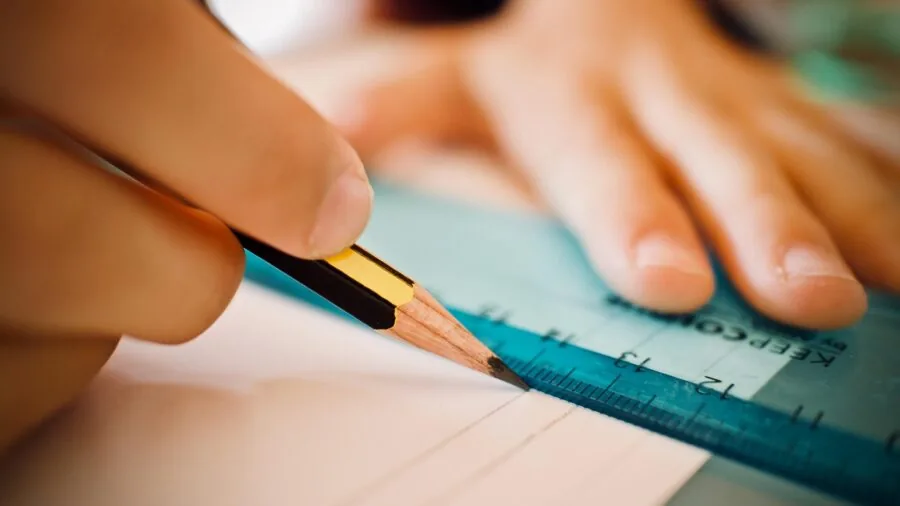 Close-up of hand writing precise details with fine-tip marker on various surfaces
