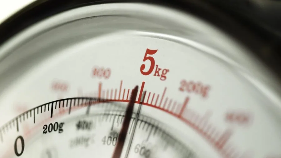 Close-up of hands adjusting a dial mechanism on a kitchen slicing tool during food preparation
