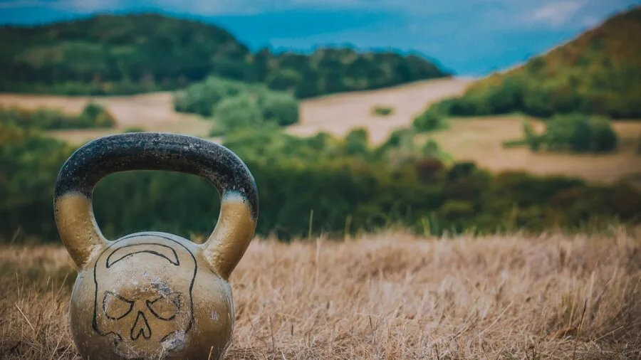 Close-up of hands adjusting kettlebell dial mechanism during home workout session