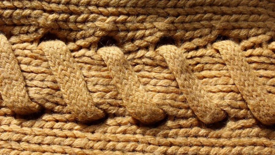 Close-up of hands examining natural wool fabric texture and material quality