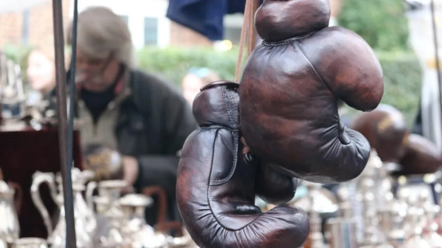 Close-up of hands feeling leather texture and quality during boxing equipment inspection
