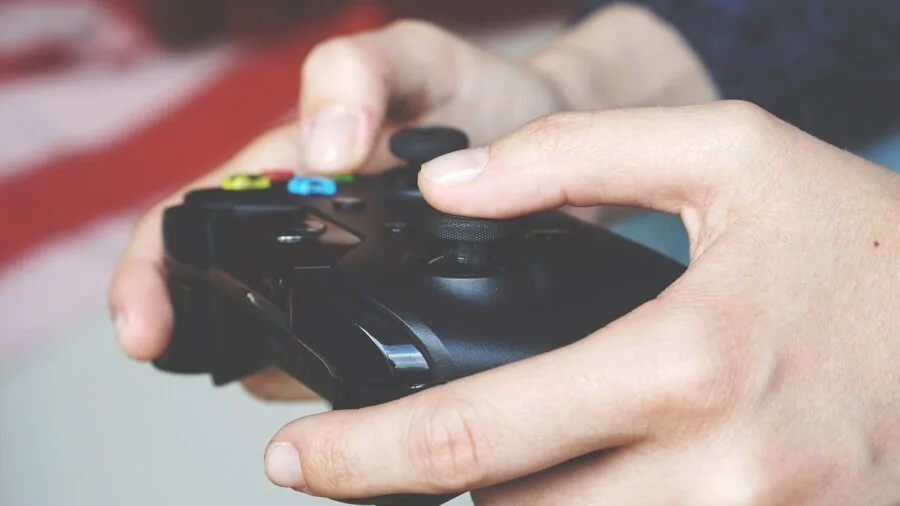 Close-up of hands holding gaming controller during gameplay session
