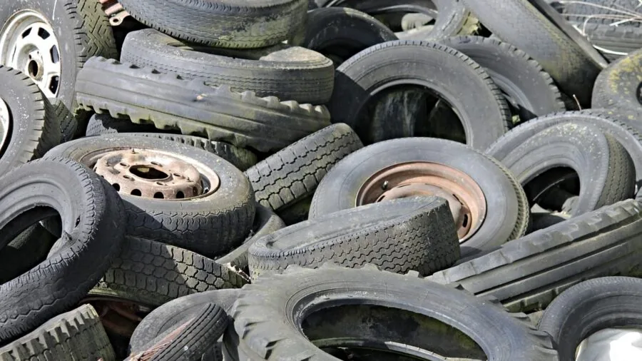 Close-up of hands inspecting black rubber tire material texture and durability