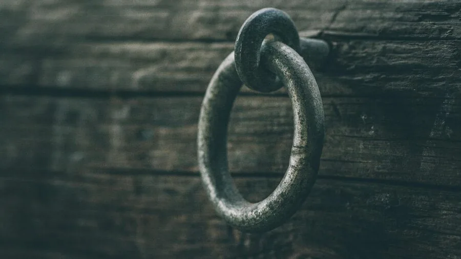 Close-up of hands inspecting metal rings for quality and durability in natural light