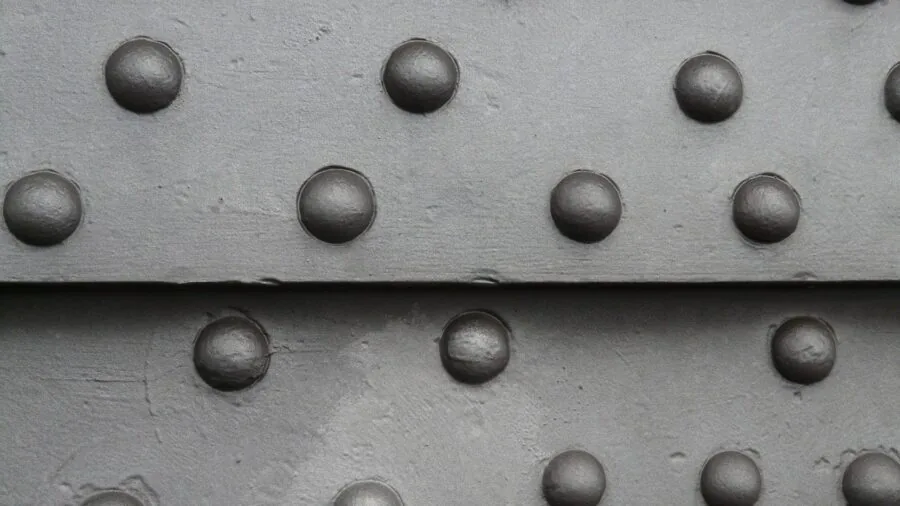 Close-up of hands measuring small metal rivets during construction work