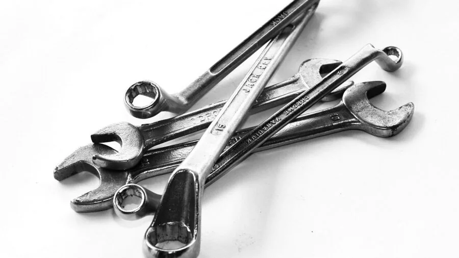 Close-up of hands operating mechanical ratchet tool during equipment maintenance work