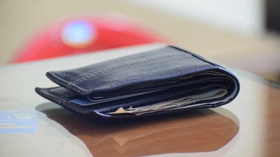 Close-up of hands organizing credit cards in a slim wallet, demonstrating secure card slot arrangement
