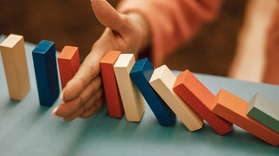 Close-up of hands placing dominoes tiles on wooden table during casual game