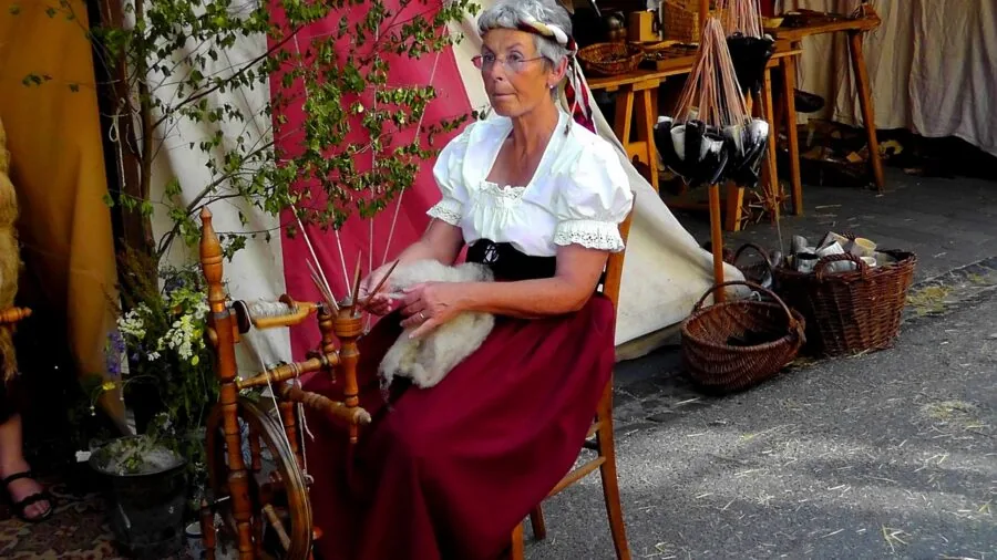 Close-up of hands working with fiber on a spinning wheel during fiber arts practice
