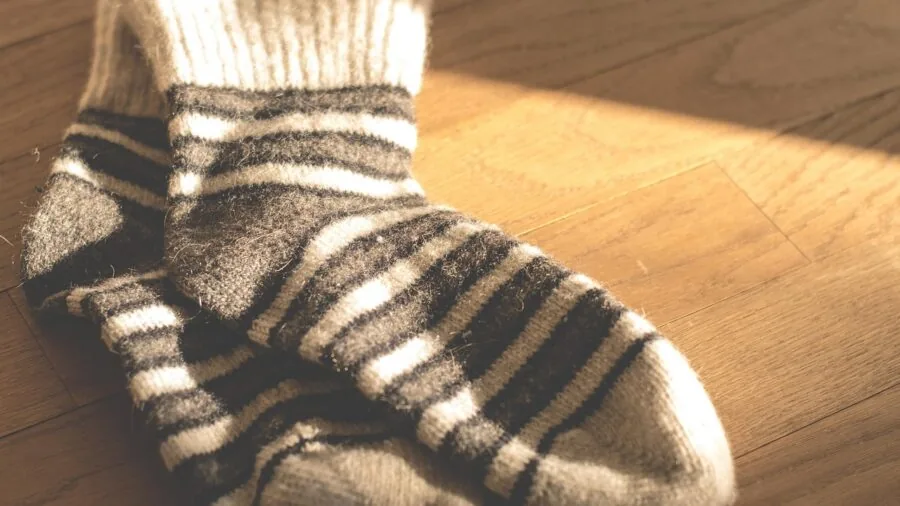 Close-up of hands working with knitting needles and yarn in natural lighting during a knitting project